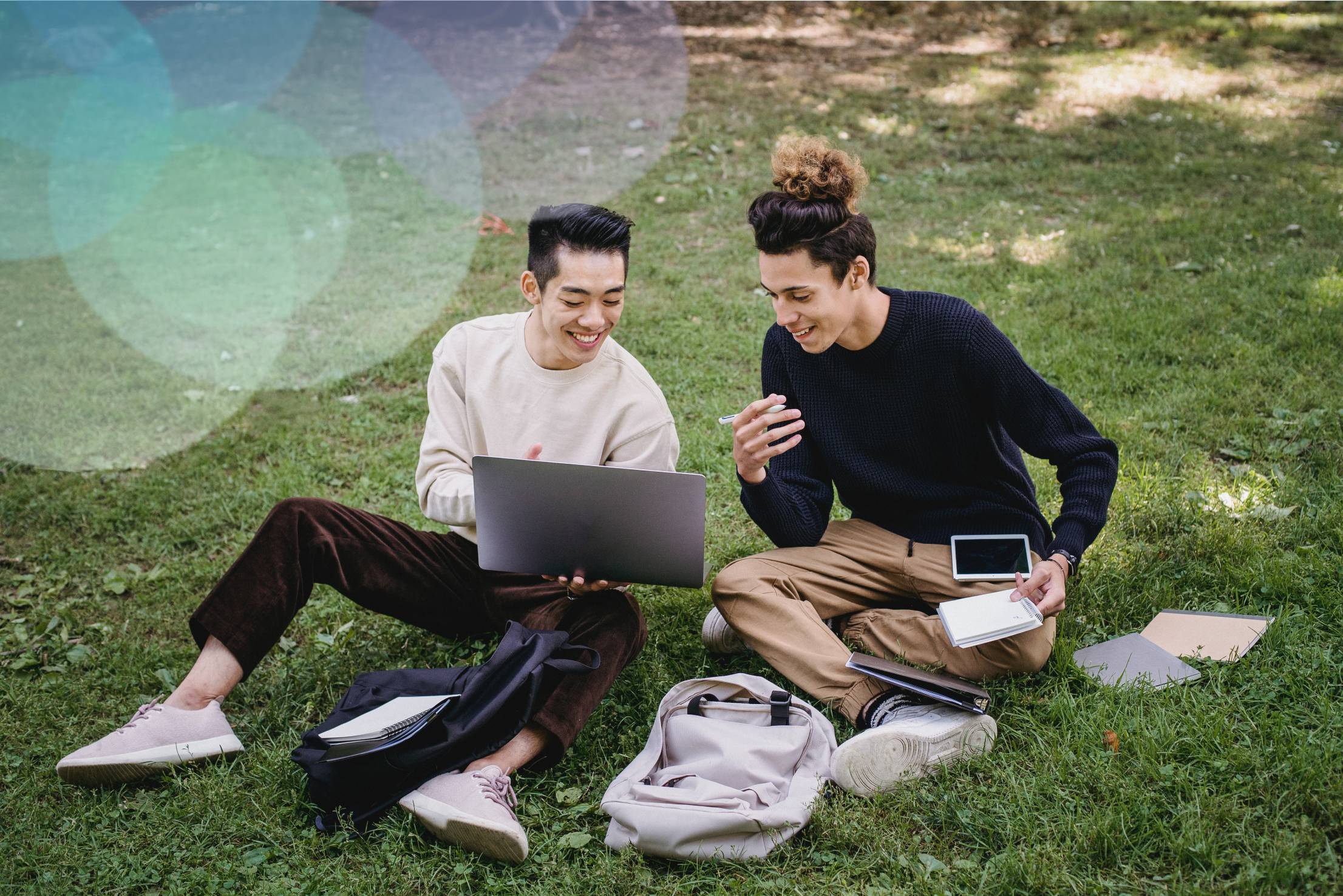 See larger image Two students looking at a laptop.