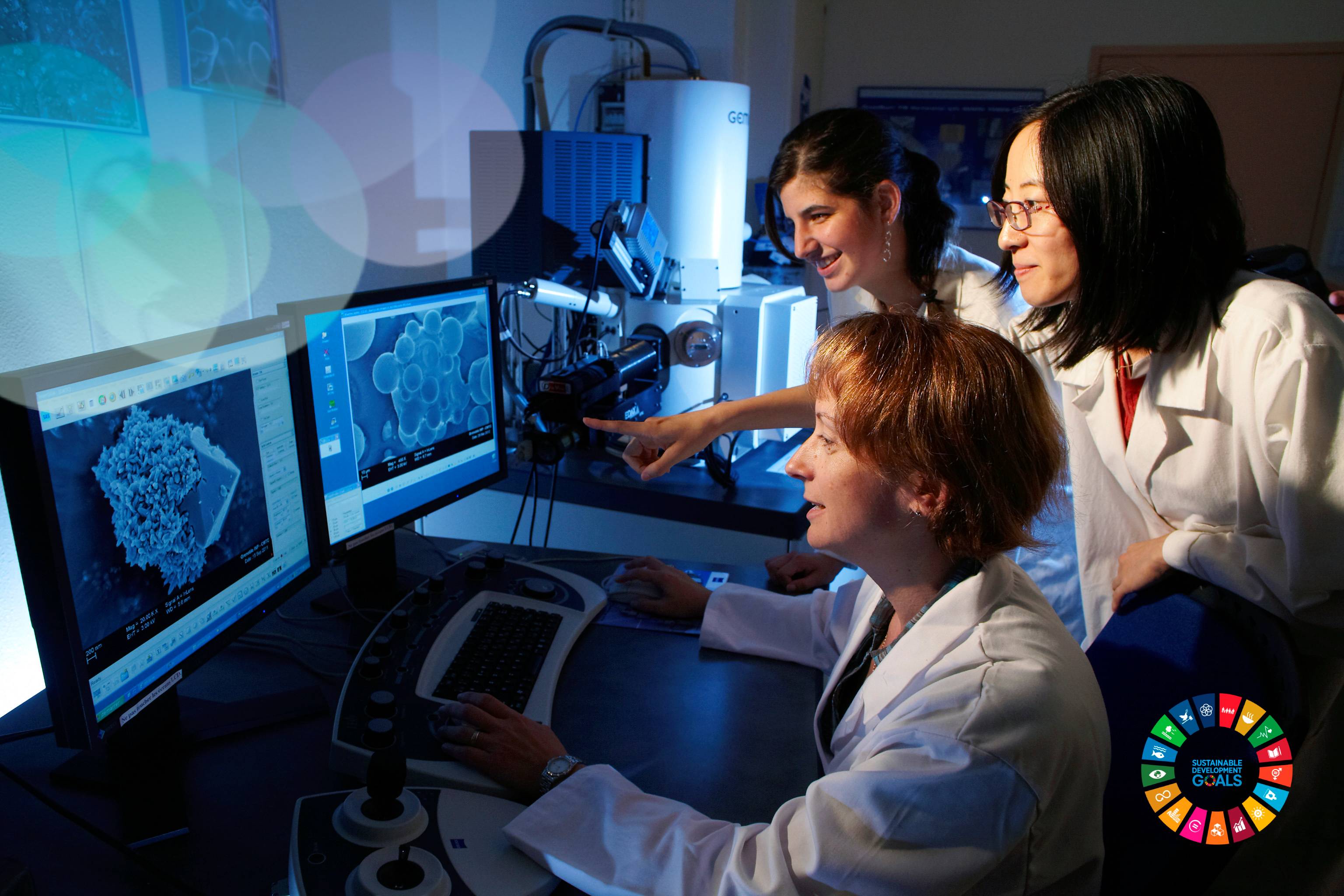 See larger image three scientists looking at a computer