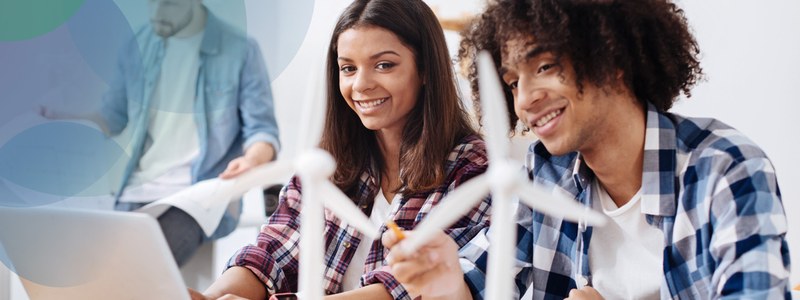 Two students working together with miniature windmills.