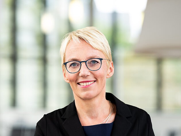 A photograph of a blonde women with glasses smiling (Tanja Brül, Unite!'s president)