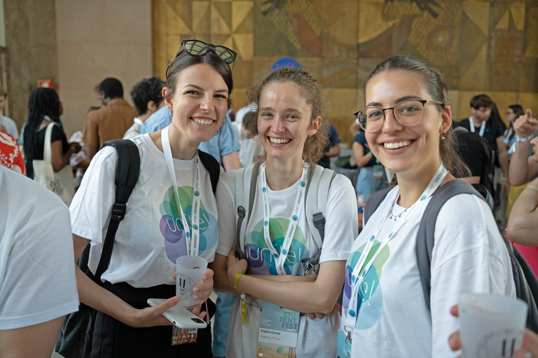 Three female students wearing a Unite! t-shirt and smiling at the camera
